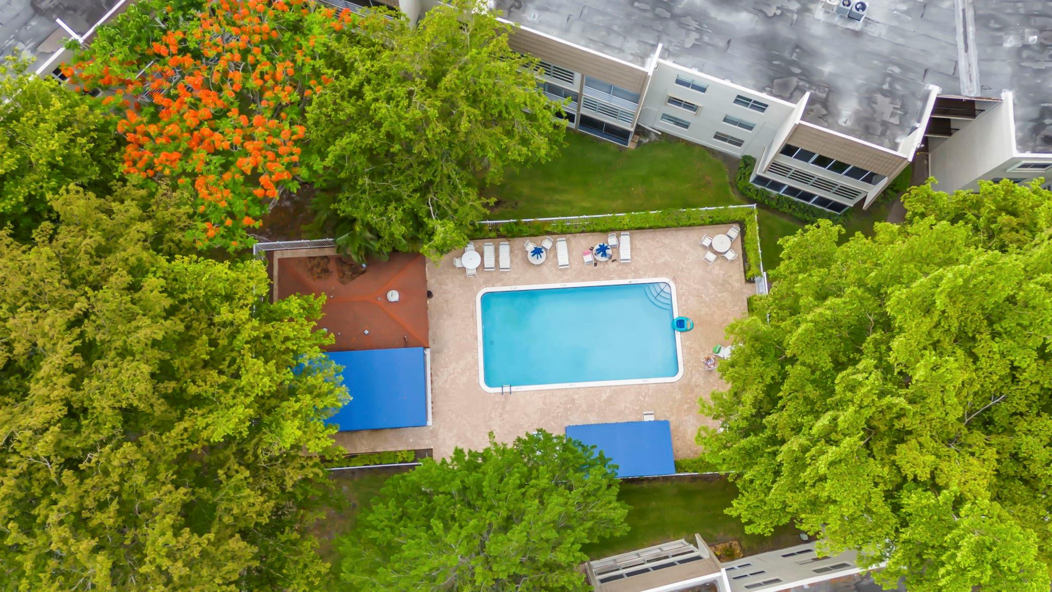 9401 Lime Bay Boulevard, Unit 209 Tamarac, FL 33321 - Photo 22 of 24 an aerial view of a house with a yard and red chairs