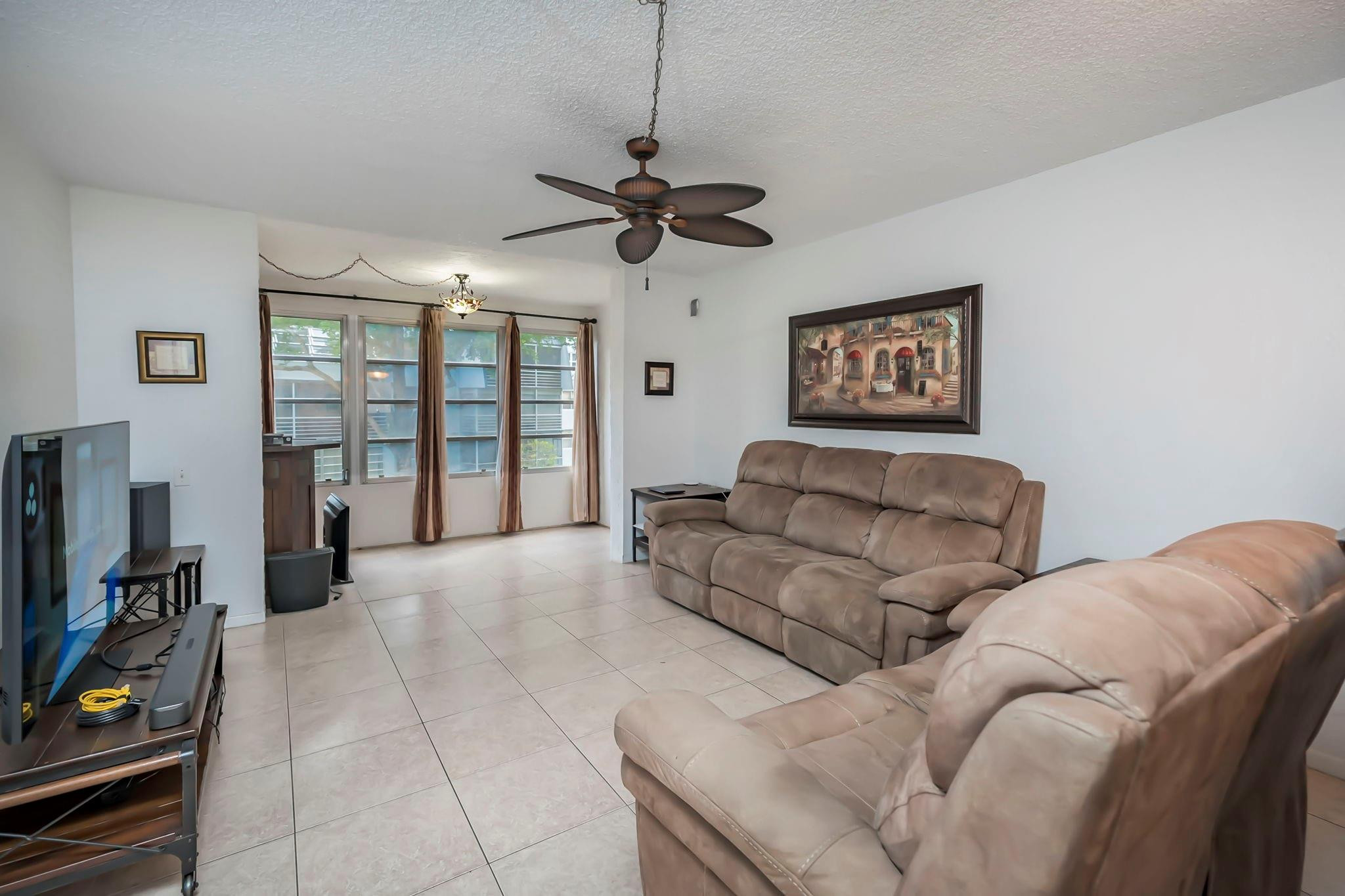 9401 Lime Bay Boulevard, Unit 209 Tamarac, FL 33321 - Photo 4 of 24 a living room with furniture and a flat screen tv