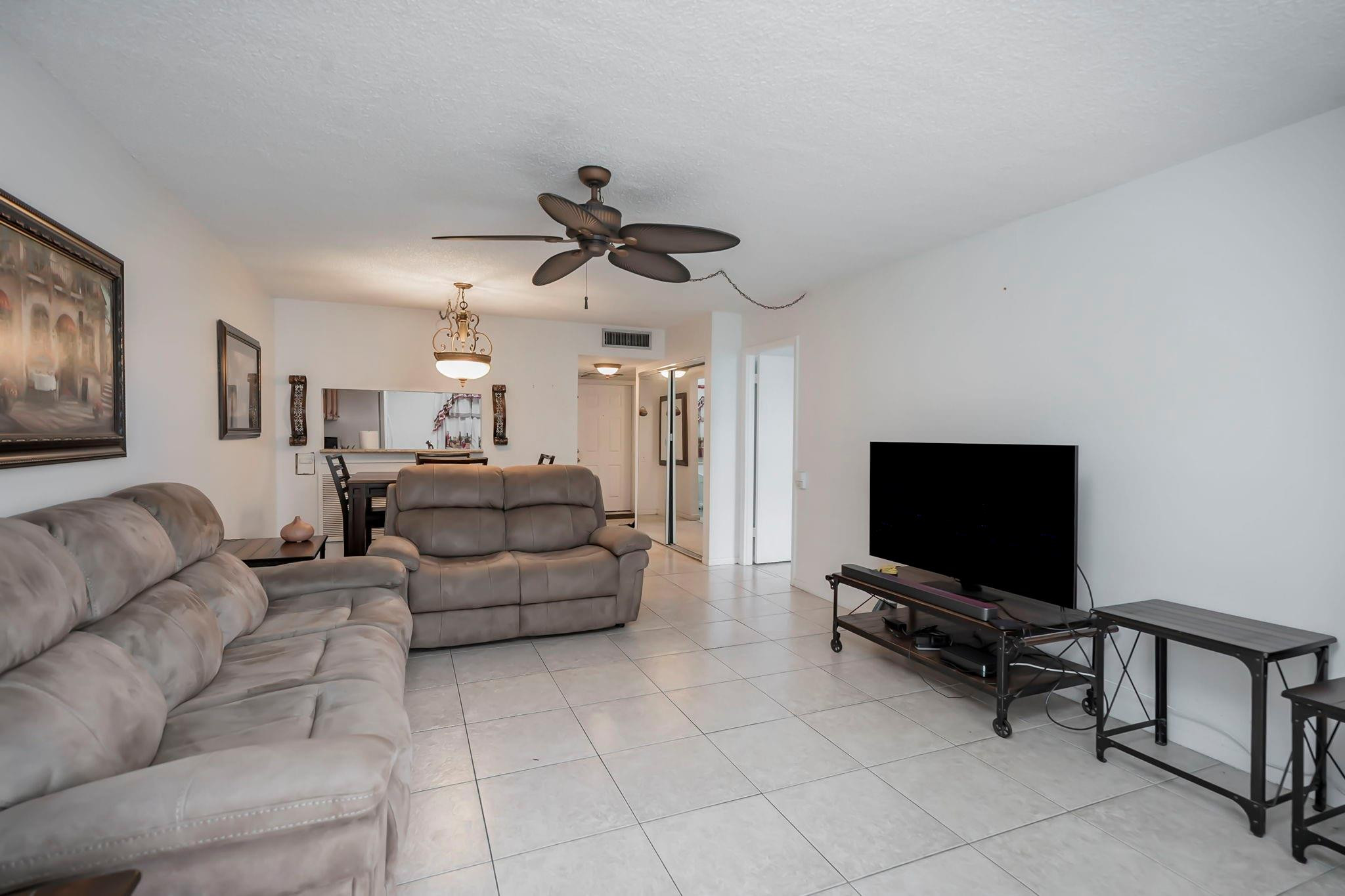 9401 Lime Bay Boulevard, Unit 209 Tamarac, FL 33321 - Photo 6 of 24 a living room with furniture and a flat screen tv