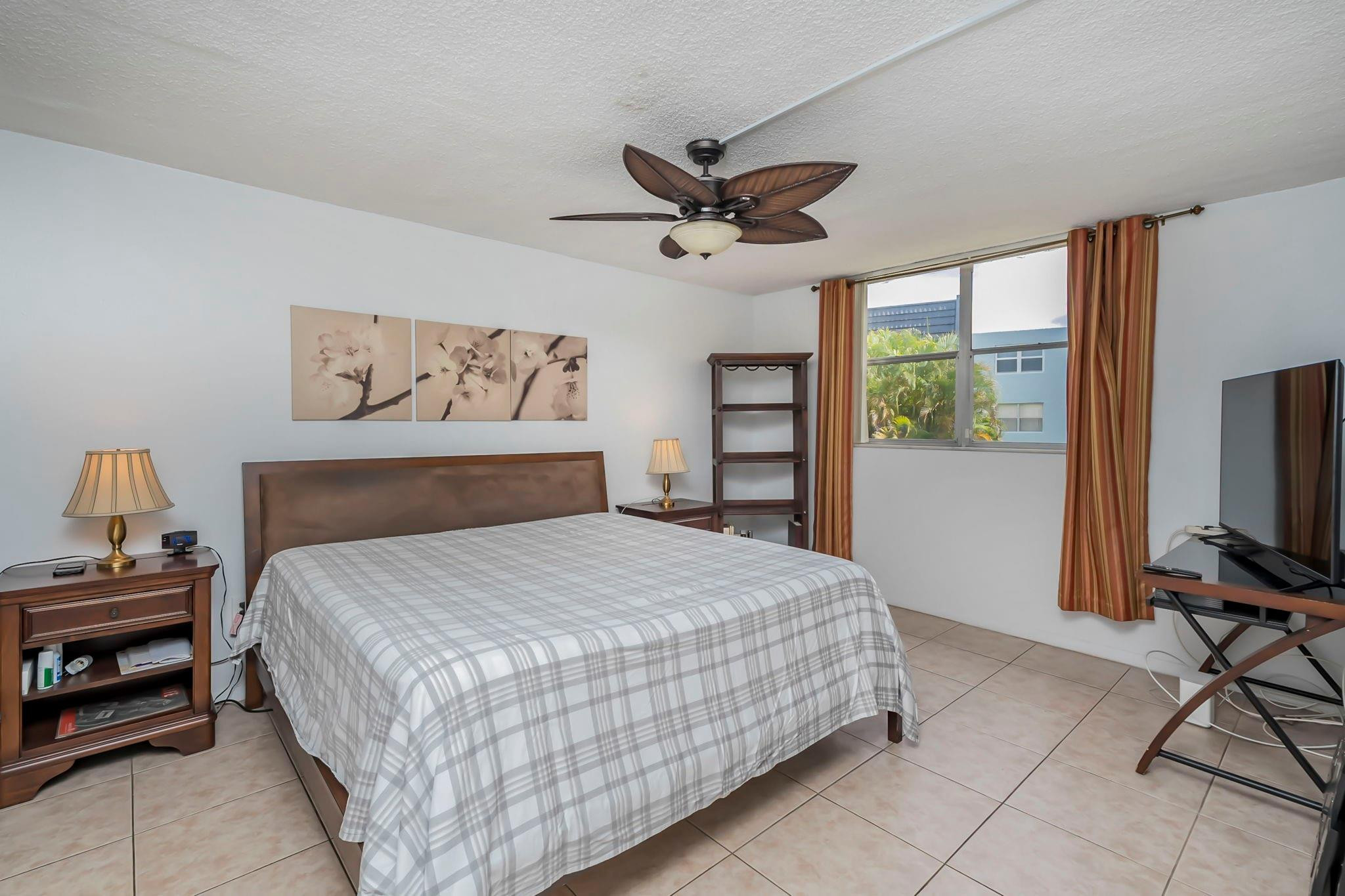 9401 Lime Bay Boulevard, Unit 209 Tamarac, FL 33321 - Photo 10 of 24 a bedroom with a bed and a tv on table