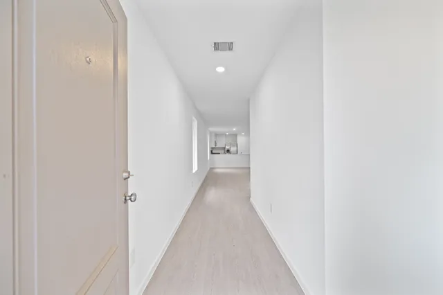 a view of a hallway with wooden floor