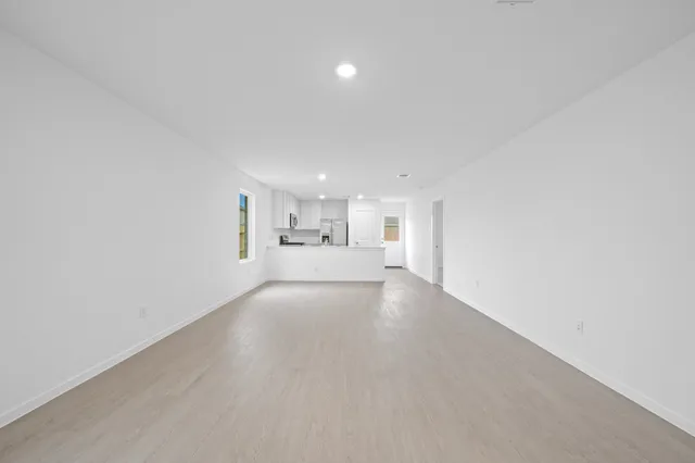 a view of empty room with kitchen
