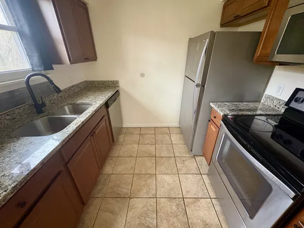 a kitchen with granite countertop a sink and a stove