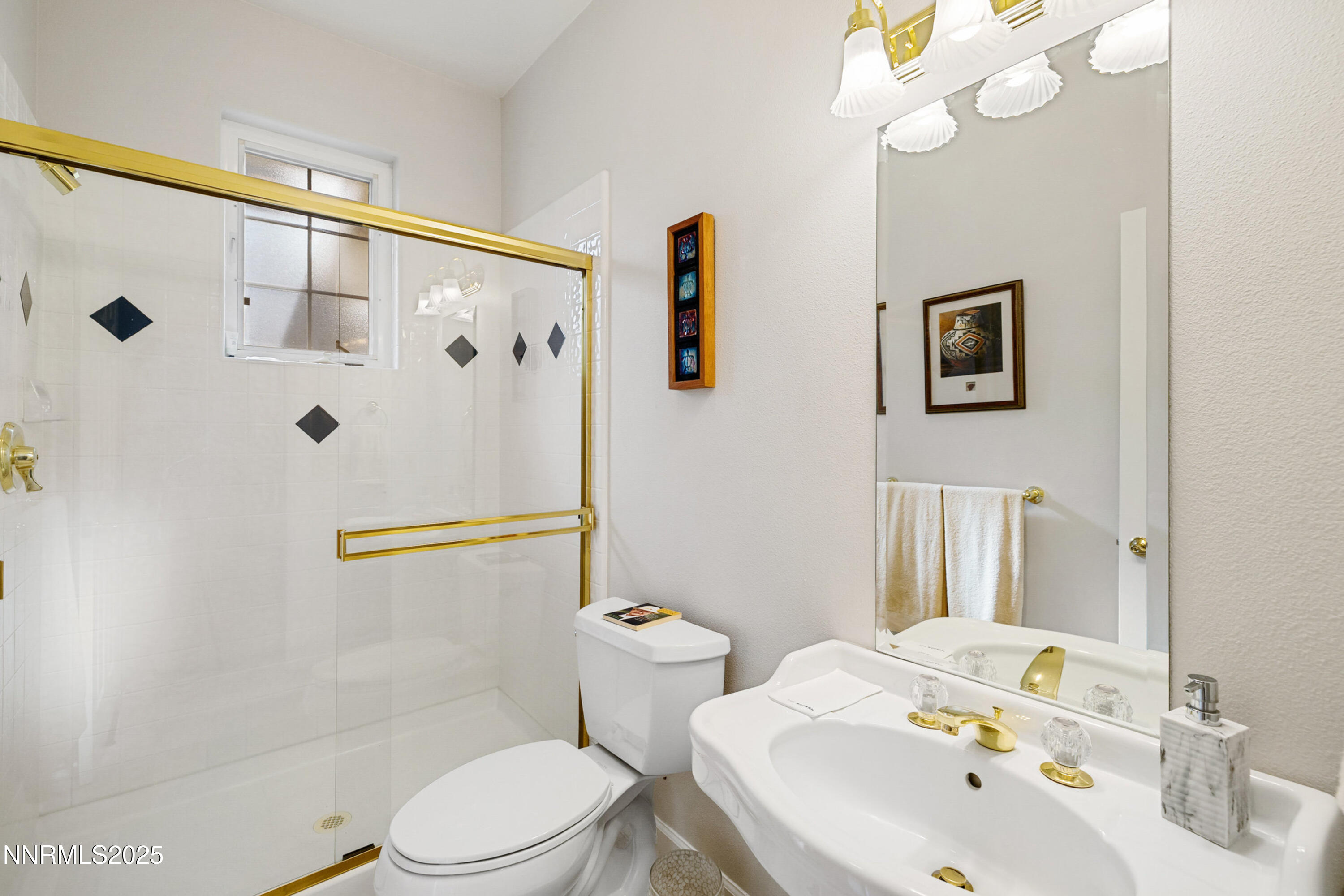 14240 Bandolier Court Reno, NV 89511 - Photo 27 of 47 a white toilet sitting next to a bathroom sink