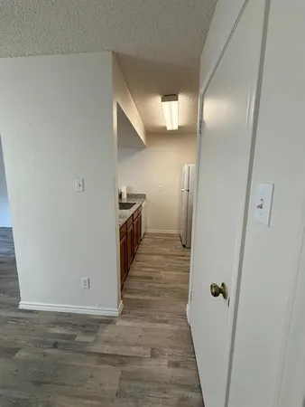 a view of a hallway with wooden floor