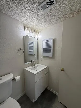 a bathroom with a toilet sink and mirror