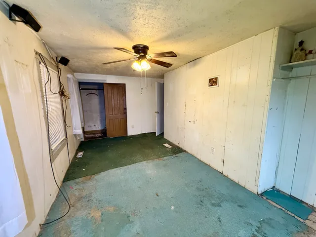 a view of a livingroom with a ceiling fan and window