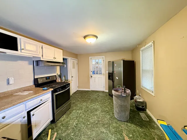 a kitchen with refrigerator a stove and a sink