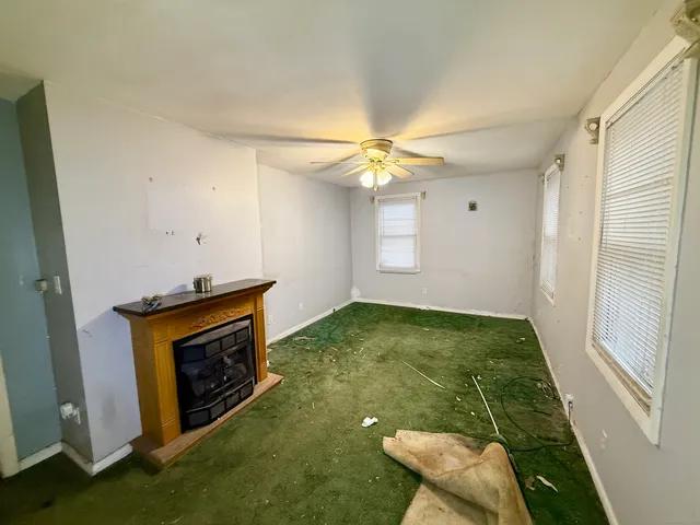 a view of an empty room with a fireplace and a window