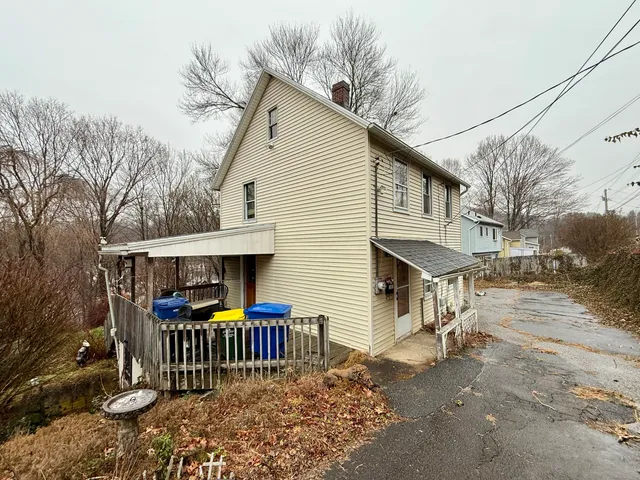 a front view of house with street and trees