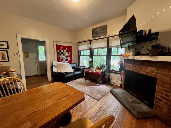 a living room with furniture a fireplace and a flat screen tv