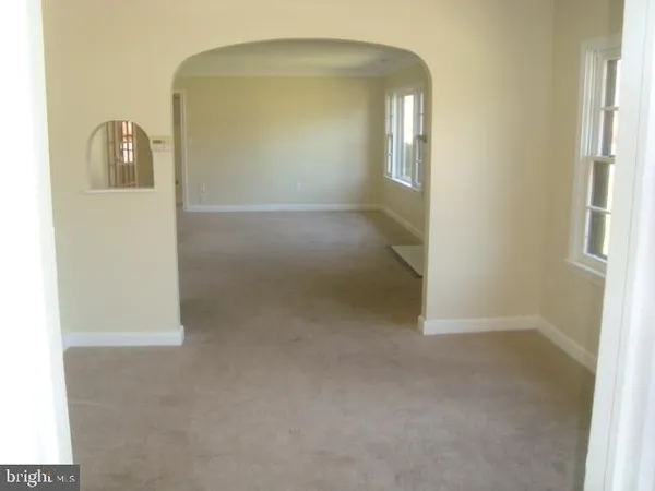 a view of a room with wooden floor and mirror