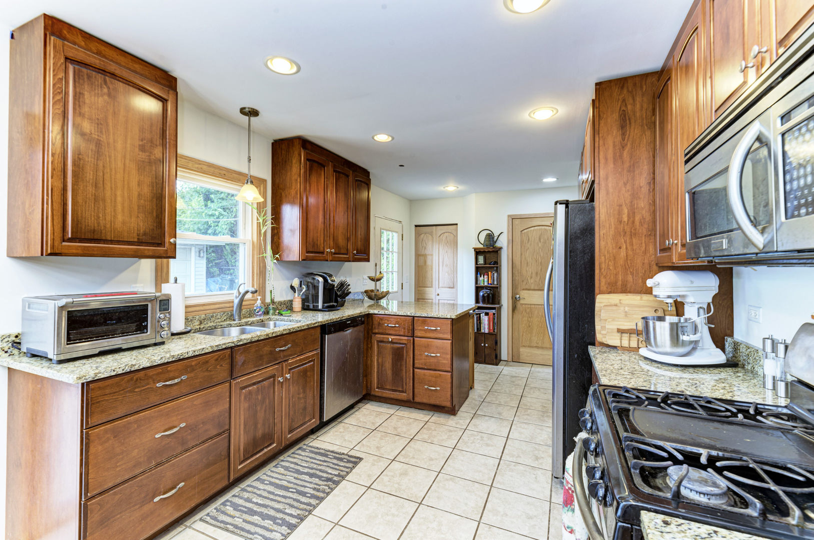 336 Hadleigh Road Bolingbrook, IL 60440 - Photo 8 of 24 a kitchen with stainless steel appliances granite countertop a stove a sink dishwasher and a refrigerator with wooden cabinets