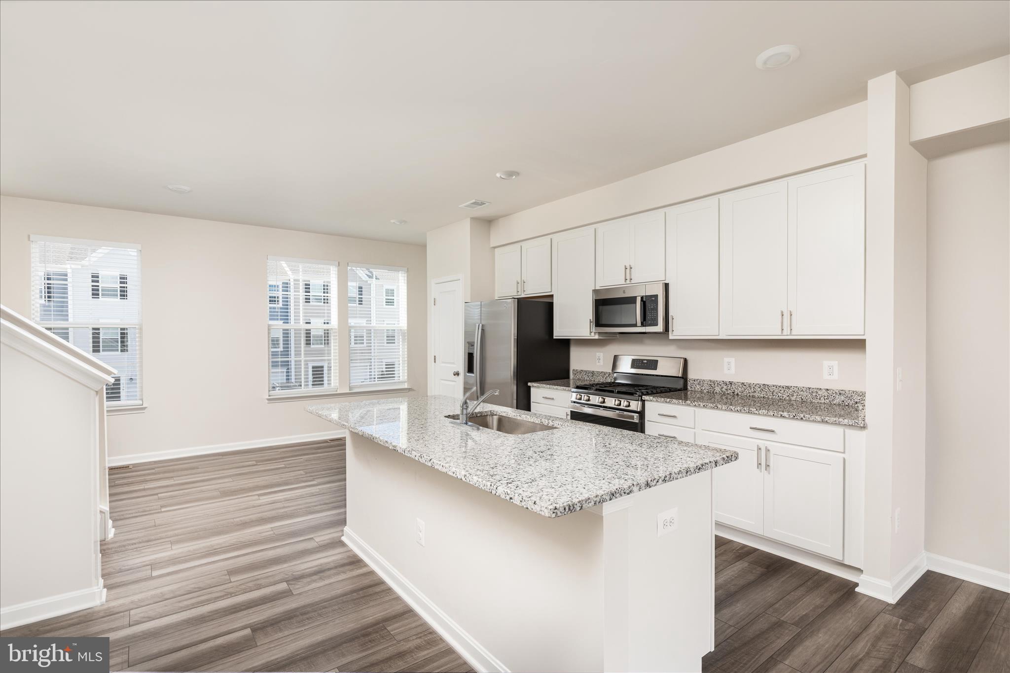140 Tye Court Winchester, VA 22602 - Photo 18 of 31 a kitchen with granite countertop a stove top oven a sink dishwasher a refrigerator and white cabinets with wooden floor