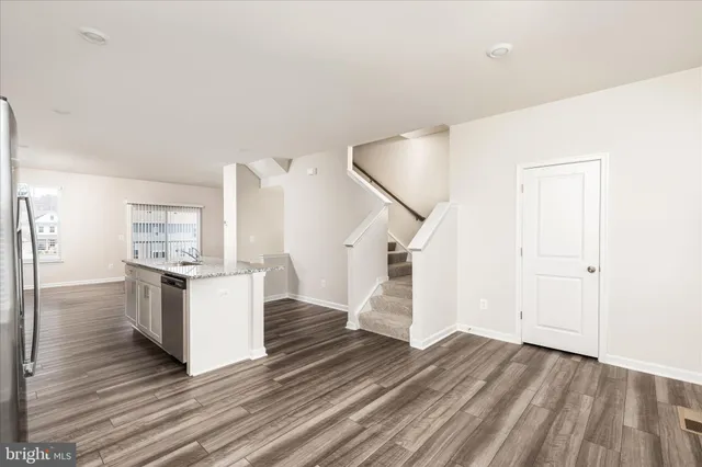 a kitchen with cabinets and wooden floor