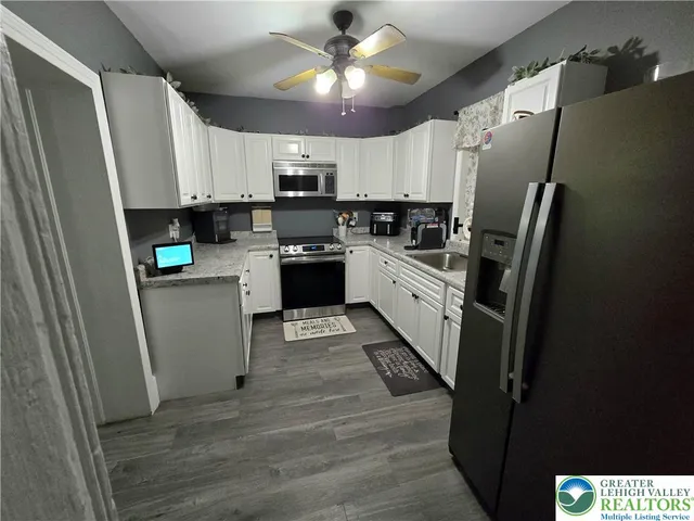 a kitchen with stainless steel appliances a refrigerator sink and microwave