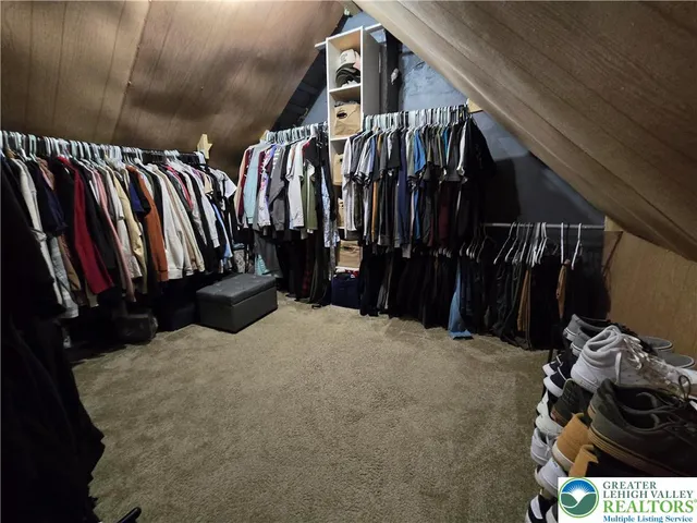 a view of walk in closet with clothes and shoes