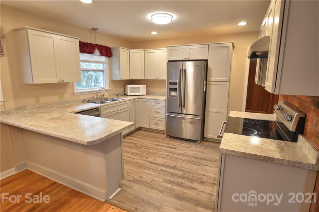 200 Bradshaw Road Tryon, NC 28782 - Photo 3 of 24 a kitchen with granite countertop a refrigerator sink and microwave