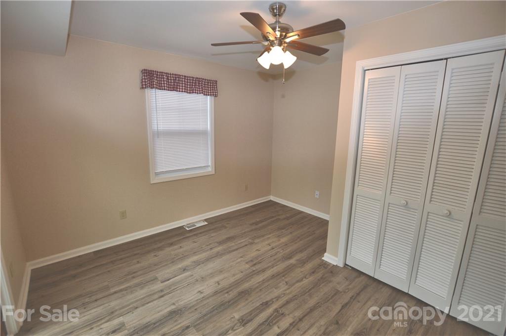 200 Bradshaw Road Tryon, NC 28782 - Photo 9 of 24 an empty room with wooden floor fan and windows