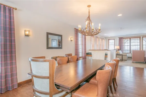 a dining room with furniture a chandelier and wooden floor