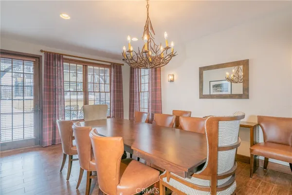 a dining room with furniture a chandelier and wooden floor