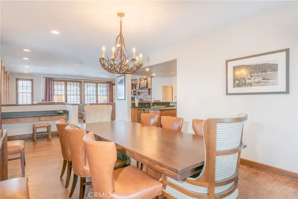 a dining room with furniture a chandelier and wooden floor