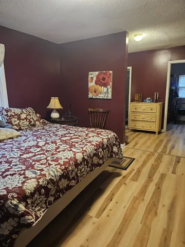 a bedroom with a bed and wooden floor