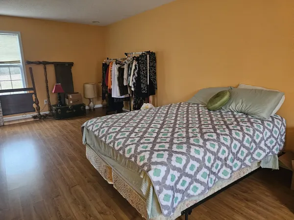 a bedroom with a bed and wooden floor