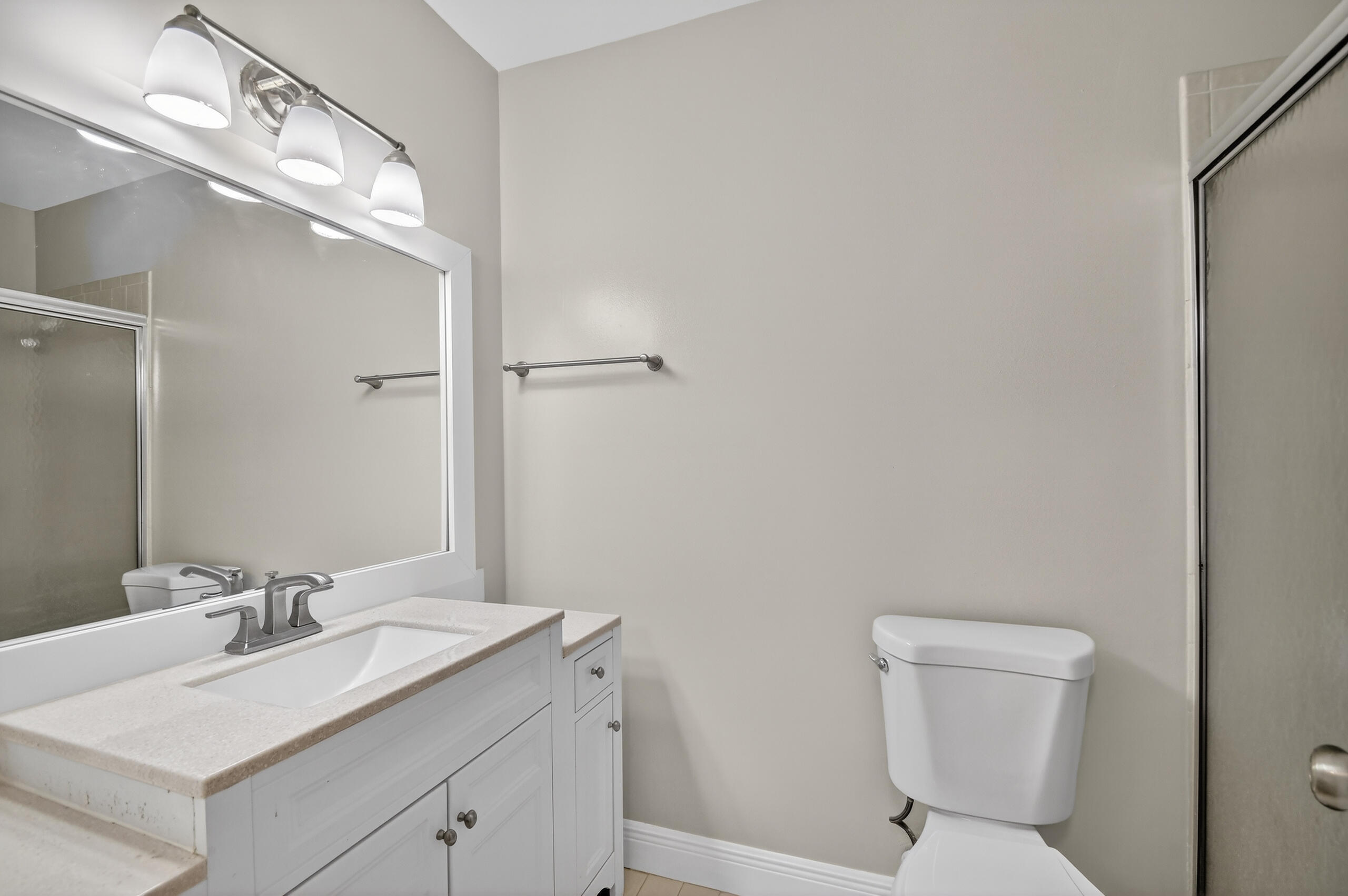 484 Springdale Circle, Unit 48D Palm Springs, FL 33461 - Photo 24 of 59 a bathroom with a toilet sink vanity and mirror
