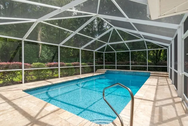 a view of a swimming pool with a patio and wooden fence
