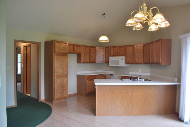 126 Windward Lane Rochelle, IL 61068 - Photo 6 of 25 a kitchen with stainless steel appliances granite countertop a refrigerator a sink dishwasher a stove and a dining table with wooden floor