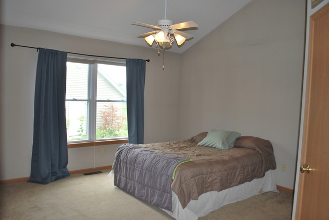 126 Windward Lane Rochelle, IL 61068 - Photo 10 of 25 a bedroom with a bed and a chandelier