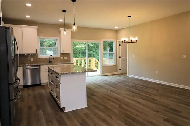 a kitchen with kitchen island a counter top space appliances and a wooden floor