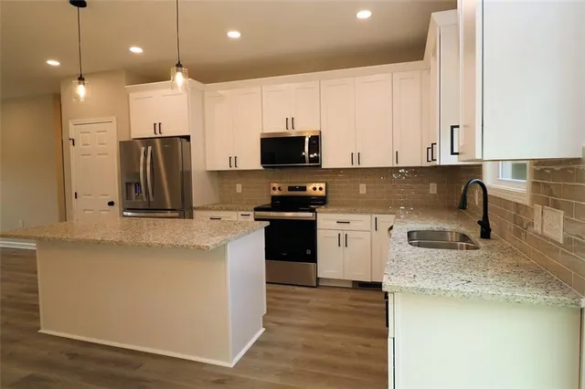 a kitchen with a refrigerator a sink and a stove
