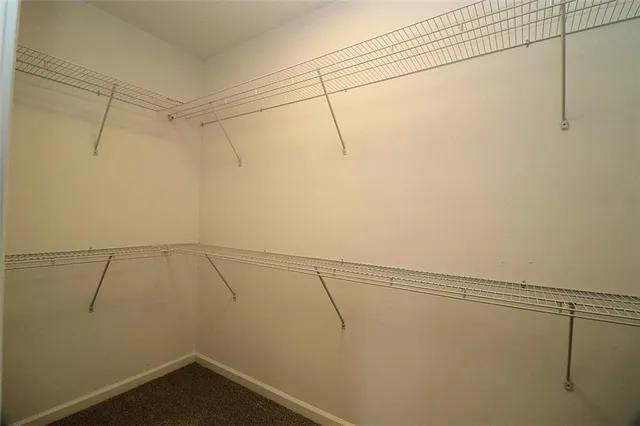 a white toilet sitting next to a white wall