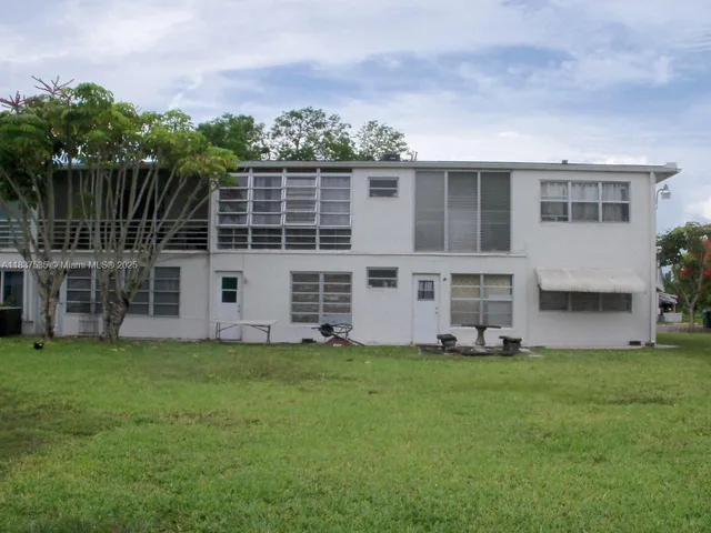 a view of a house with backyard sitting area and garden