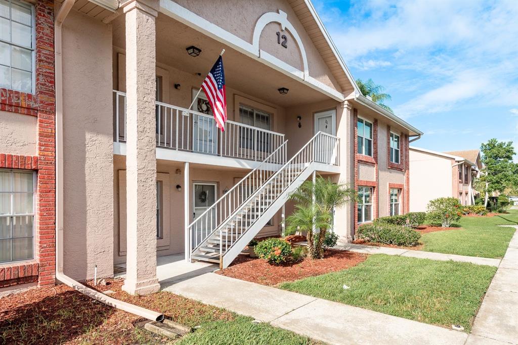 6410 Spring Flower Drive, Unit 26 New Port Richey, FL 34653 - Photo 1 of 38 a view of a house with a small yard and potted plants