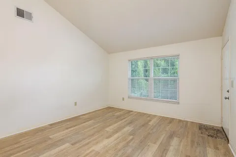 an empty room with a window and a fan