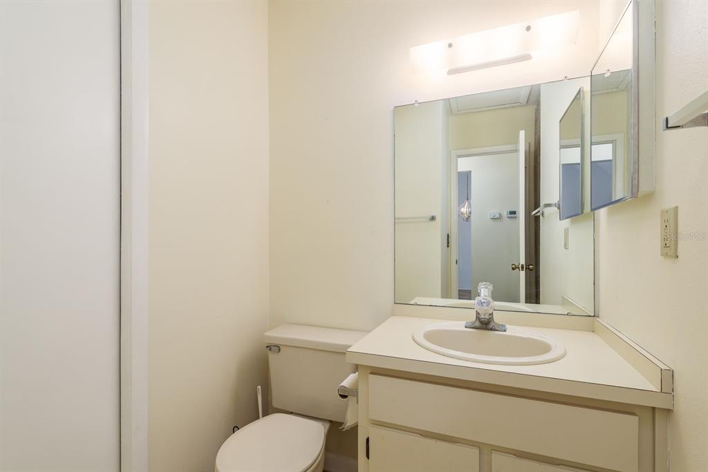 6410 Spring Flower Drive, Unit 26 New Port Richey, FL 34653 - Photo 22 of 38 a bathroom with a toilet sink and mirror
