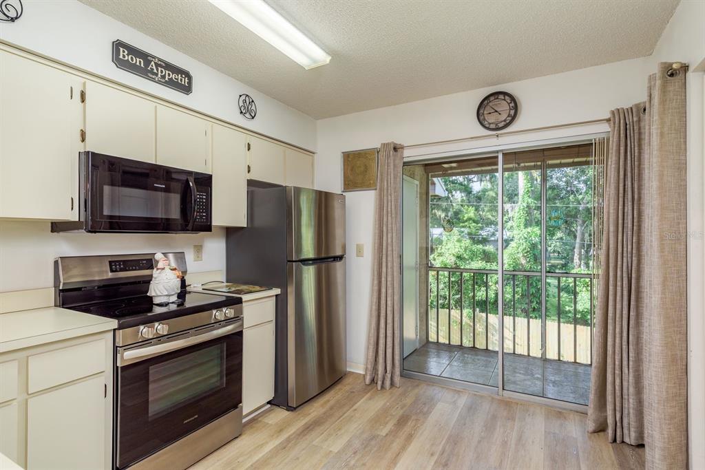 6410 Spring Flower Drive, Unit 26 New Port Richey, FL 34653 - Photo 3 of 38 a kitchen with stainless steel appliances a stove microwave and refrigerator