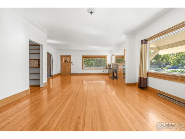a big room with wooden floor and windows
