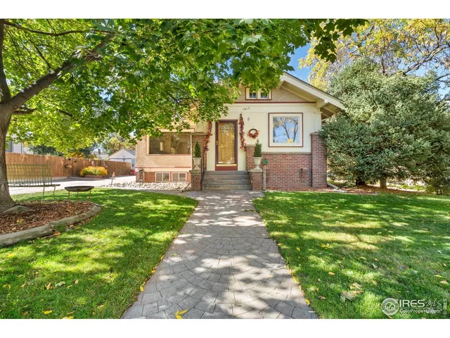 a front view of a house with a yard and trees