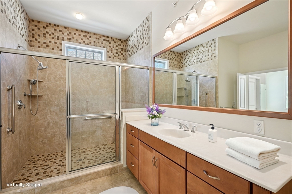 17 West View Lane, Unit 17 Stow, MA 01775 - Photo 11 of 32 a bathroom with a double vanity sink mirror and shower