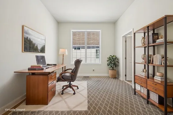 a view of a workspace with furniture and a window