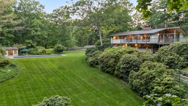 a aerial view of a house next to a big yard and large trees