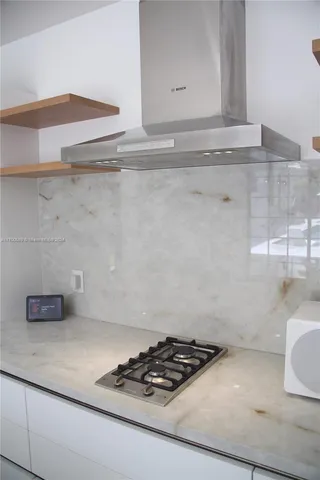 a view of a white house with a small yard and plants