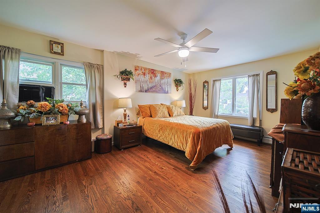 1003 Cumbermeade Road Fort Lee, NJ 07024 - Photo 17 of 38 a bedroom with a bed and wooden floor