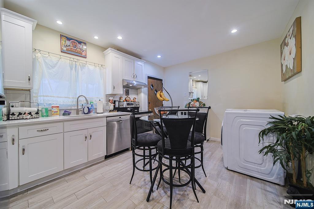 1003 Cumbermeade Road Fort Lee, NJ 07024 - Photo 10 of 38 a kitchen with a table chairs sink and cabinets