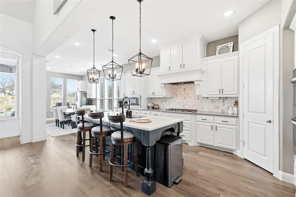 6508 Cooper Creek Road Flower Mound, TX 76226 - Photo 11 of 39 a kitchen with kitchen island granite countertop a sink a center island and cabinets