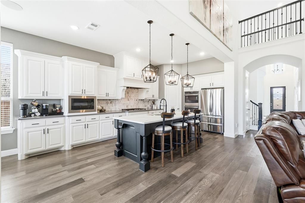 6508 Cooper Creek Road Flower Mound, TX 76226 - Photo 12 of 39 a kitchen with stainless steel appliances kitchen island granite countertop a stove a sink a center island and cabinets